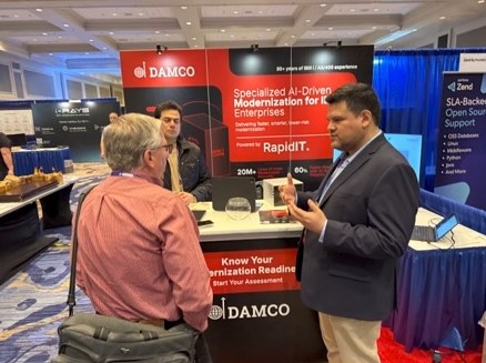 A Damco consultant talking with a visitor at the Damco booth